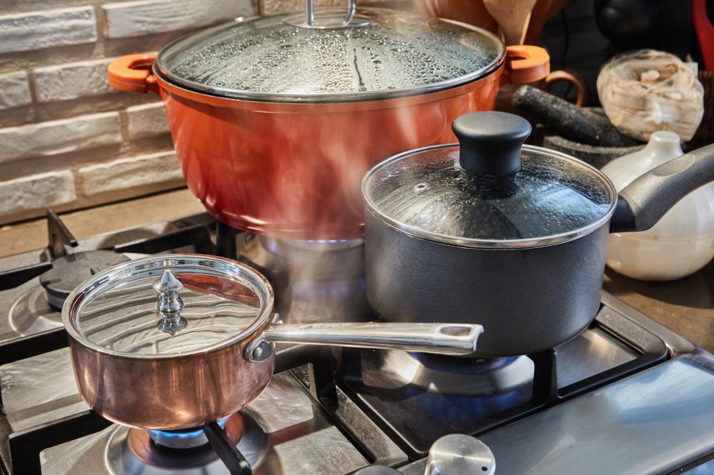 Pots with cooking food in the kitchen on gas stove
